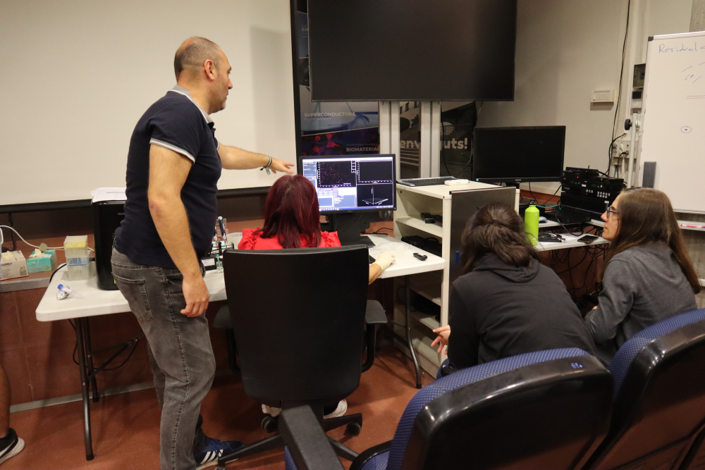 Amable Bernabé showing the materials' characterization equipment to the course participants